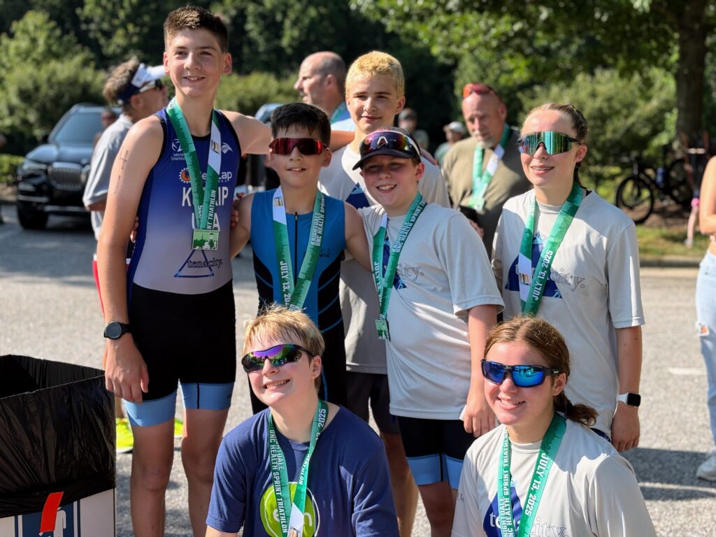 A group photo of Tenacity triathletes after a race